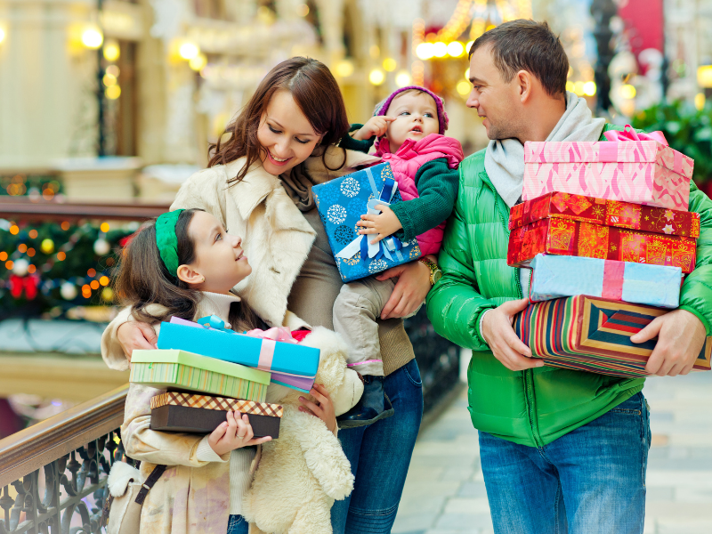 Family carrying Christmas presents they shopped.